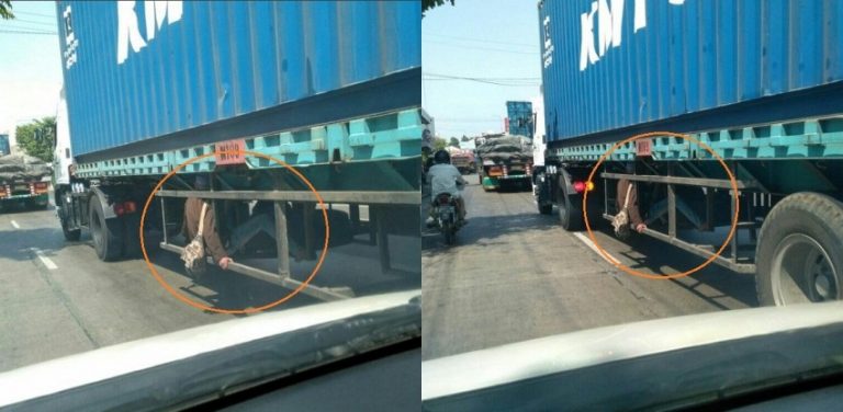 Sosok di bawah truk kontainer ini bikin pengendara lain kaget udah kaya punya nyawa sembilan selonjoran disana